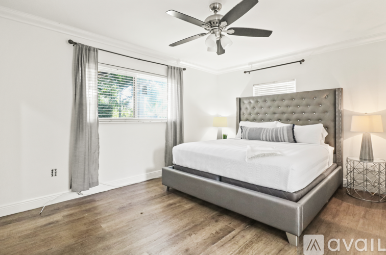 A bedroom with a large bed and a ceiling fan.