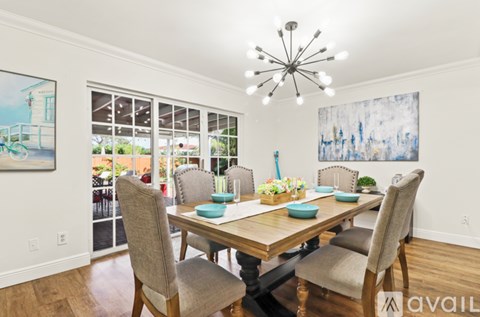 A dining room with a wooden table and chairs.