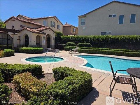 A pool with a fountain in the middle of a yard.