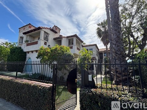 A house with a black fence and gate in front of it.