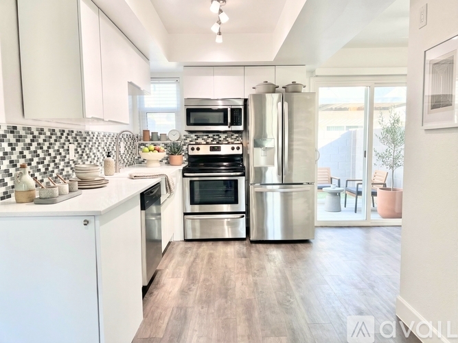 A modern kitchen with stainless steel appliances and white cabinetry.