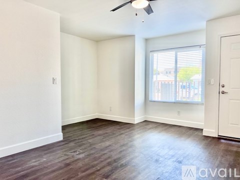 A spacious room with a ceiling fan and a window with blinds.