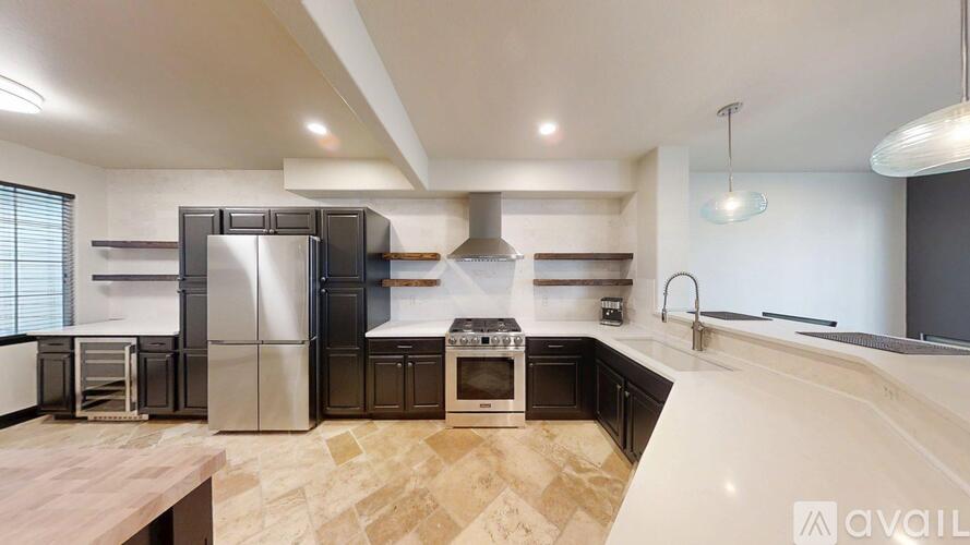 A modern kitchen with a wooden table and stainless steel appliances.