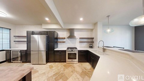 A modern kitchen with a wooden table and stainless steel appliances.