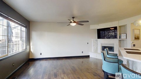 A living room with a fireplace and a television mounted above it.