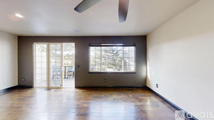 A spacious room with a sliding glass door leading to a balcony.