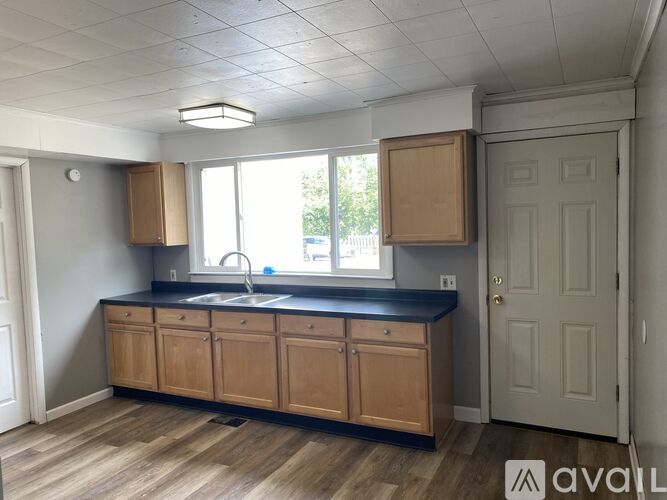 A kitchen with wooden cabinets and a black countertop.