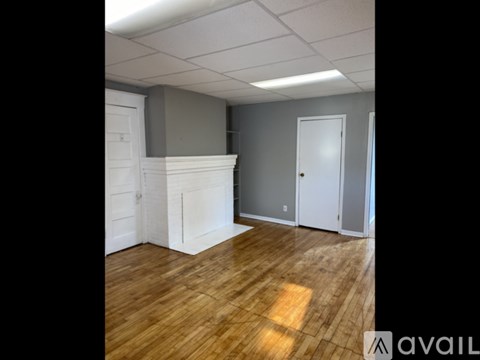 A room with wooden flooring and white walls.