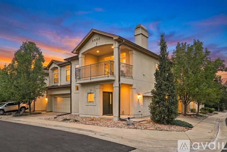 A modern two-story house with a balcony and a garage.