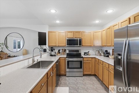 A kitchen with wooden cabinets and stainless steel appliances.