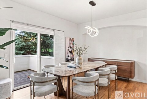 A dining room with a wooden table and grey chairs.