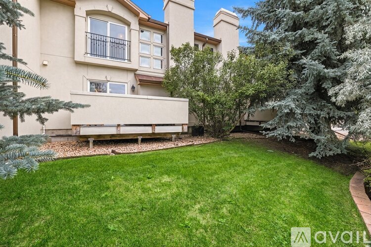 A house with a well-manicured lawn and trees.
