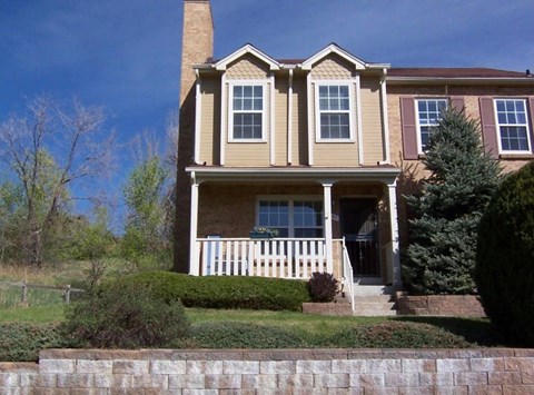A house with a brown roof and a white fence.