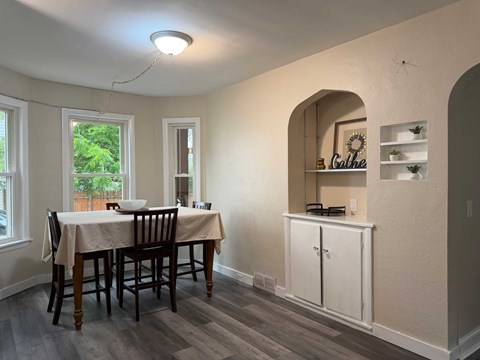 A dining room with a table and chairs.