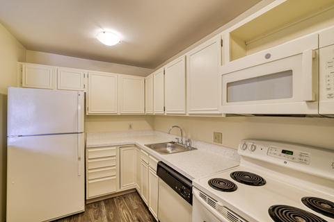 A kitchen with white appliances and cabinets.