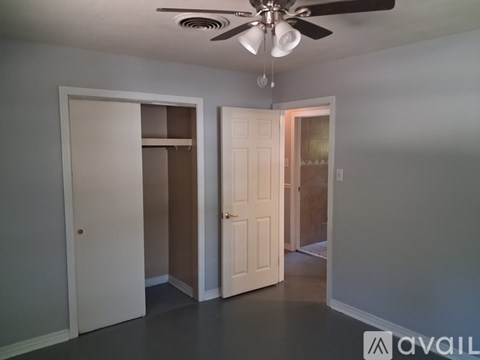 A room with a ceiling fan and three doors.
