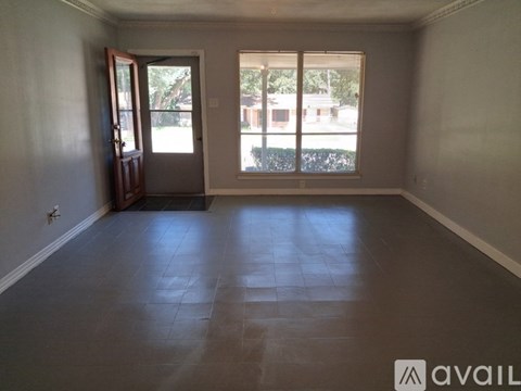 A room with a tiled floor and a sliding glass door leading outside.