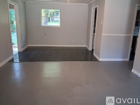 A spacious room with a window and tile flooring.
