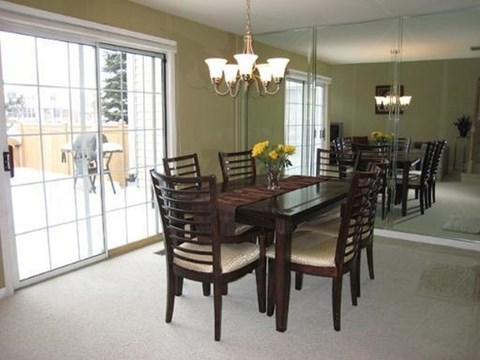 A dining room with a table and chairs.