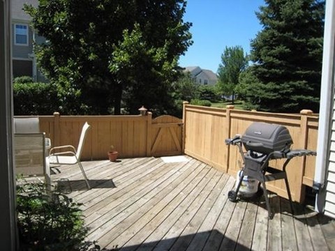 A baby stroller is sitting on a wooden deck.