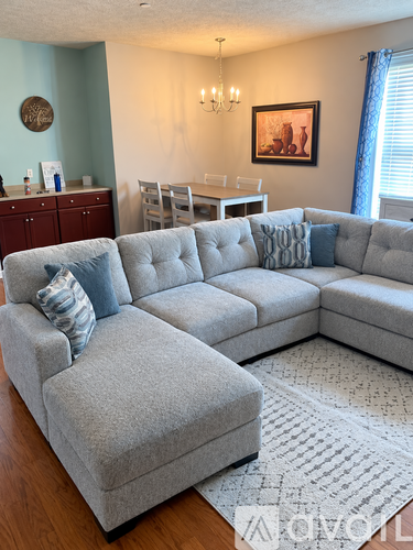 A grey sectional sofa with pillows in a living room.