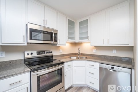 A kitchen with white cabinets and a stainless steel dishwasher.