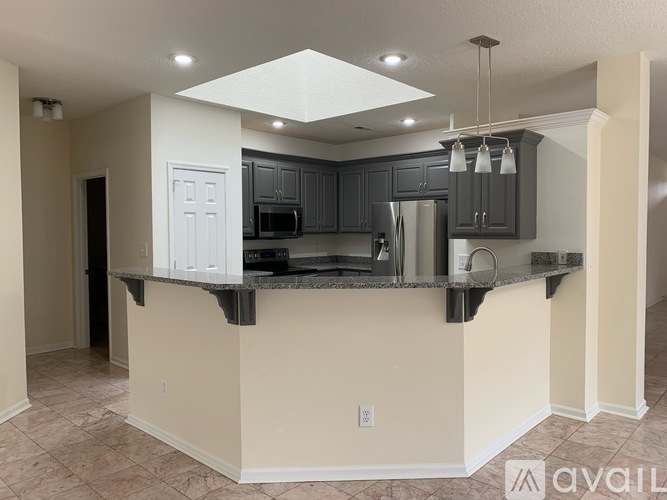 A kitchen with a granite countertop and a white door.