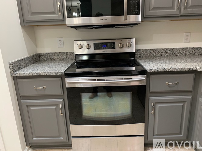 A modern kitchen with a stove top oven and microwave above it.