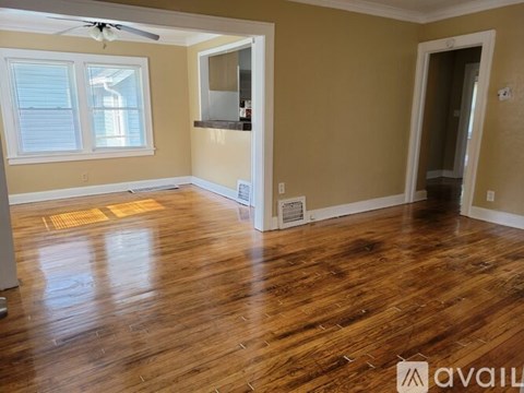 A room with wooden floors and a ceiling fan.