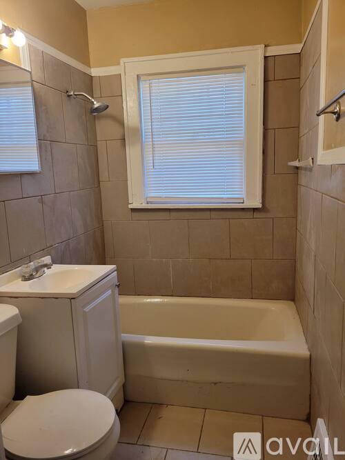 A bathroom with a toilet, sink, and bathtub.