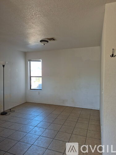 A room with a tiled floor and a window.