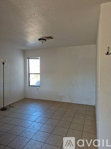 A room with a tiled floor and a window.