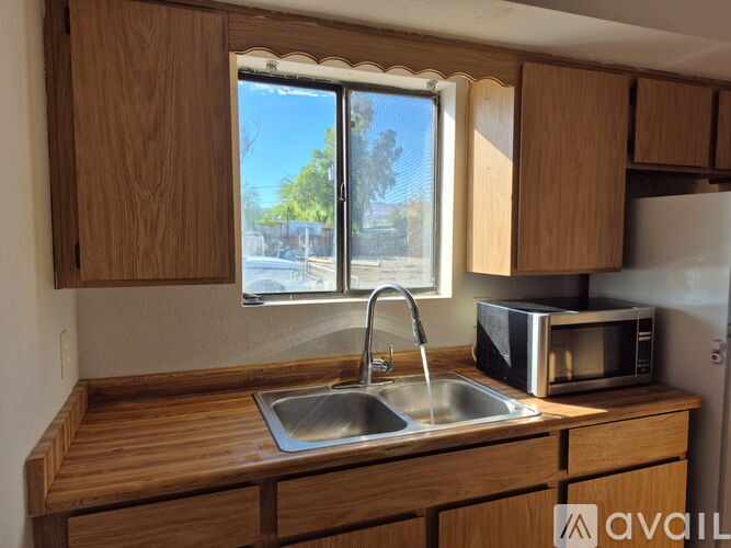 A kitchen with wooden cabinets and a stainless steel sink.