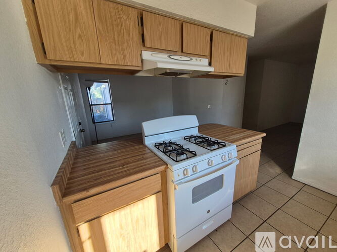 A kitchen with a white stove and wooden cabinets.