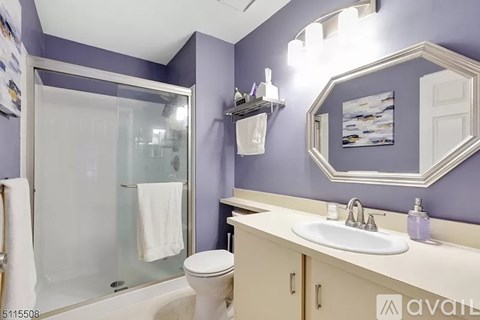 A bathroom with purple walls and a white toilet.