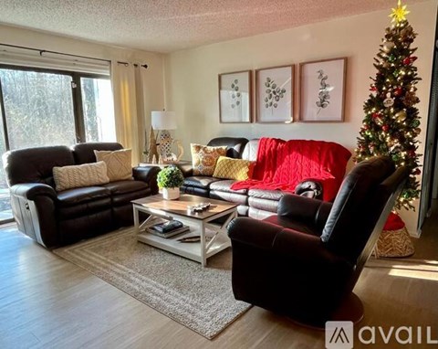A living room with a Christmas tree and a couch.