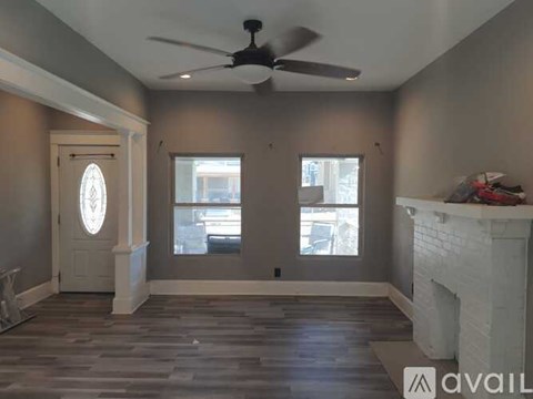 A room with a fireplace and a ceiling fan.