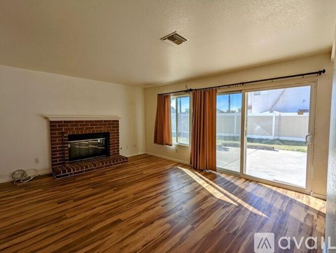 A living room with a fireplace and sliding glass doors.