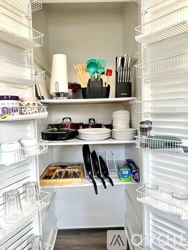 A white refrigerator is full of food and kitchen supplies.