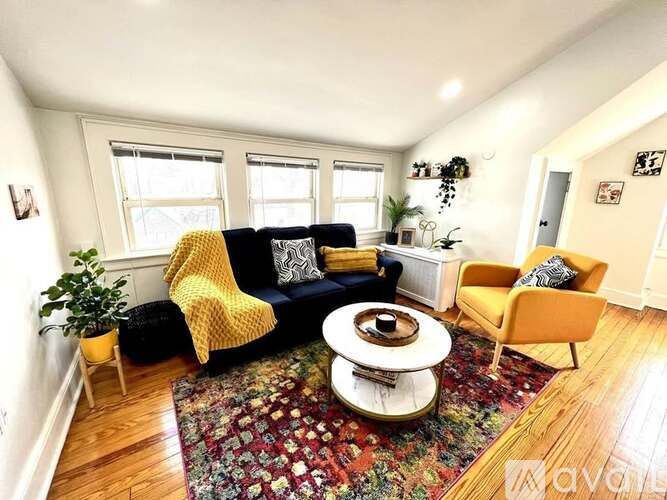 A living room with a yellow chair and a patterned rug.