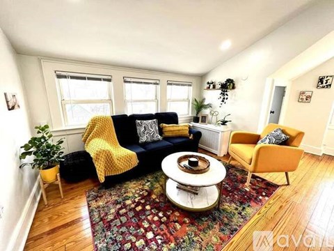A living room with a yellow chair and a patterned rug.