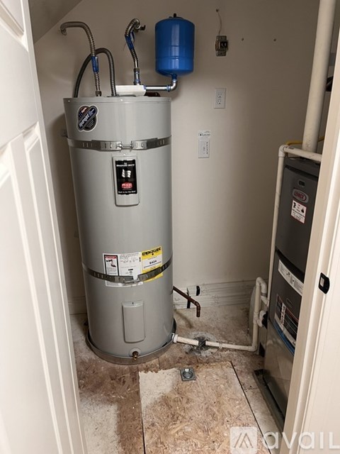 A water heater in a room with a white wall.