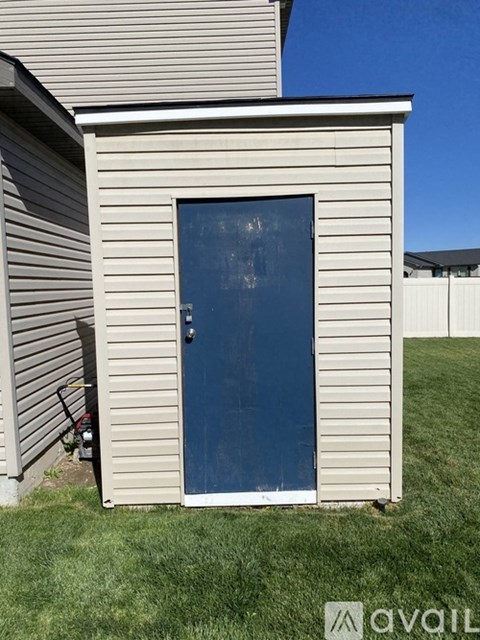 A small blue door is on the side of a house.