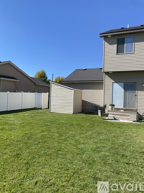 A house with a white fence and a green lawn.