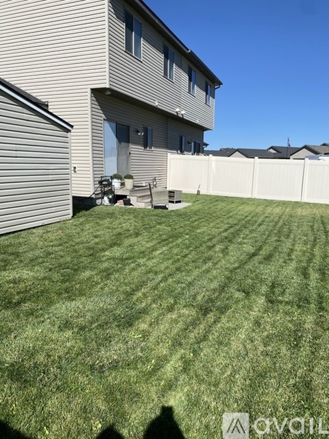 A house with a white fence and a green lawn.