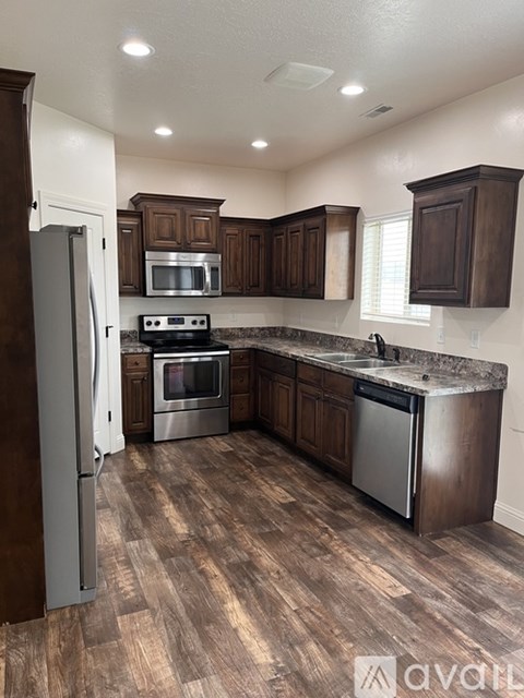 A kitchen with dark wood cabinets and stainless steel appliances.