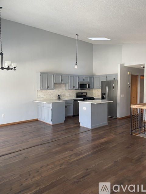 A kitchen with wooden floors and a white island.