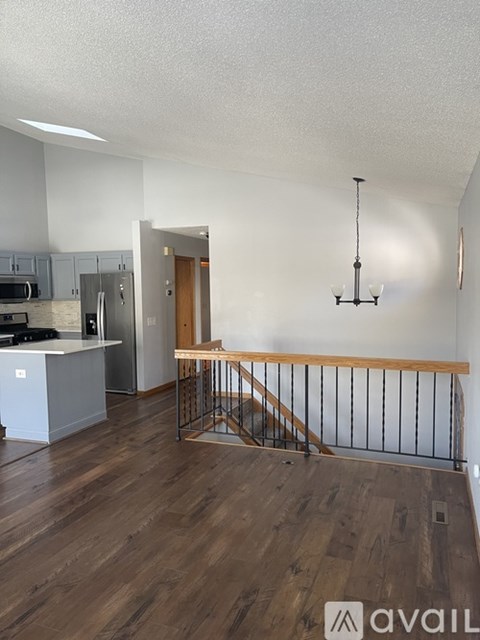 A living room with a staircase and a kitchen area.