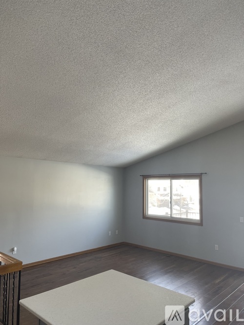 A room with a window and a table in it.