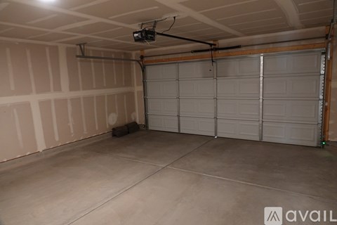 A spacious garage with a closed white door and a ceiling fan.